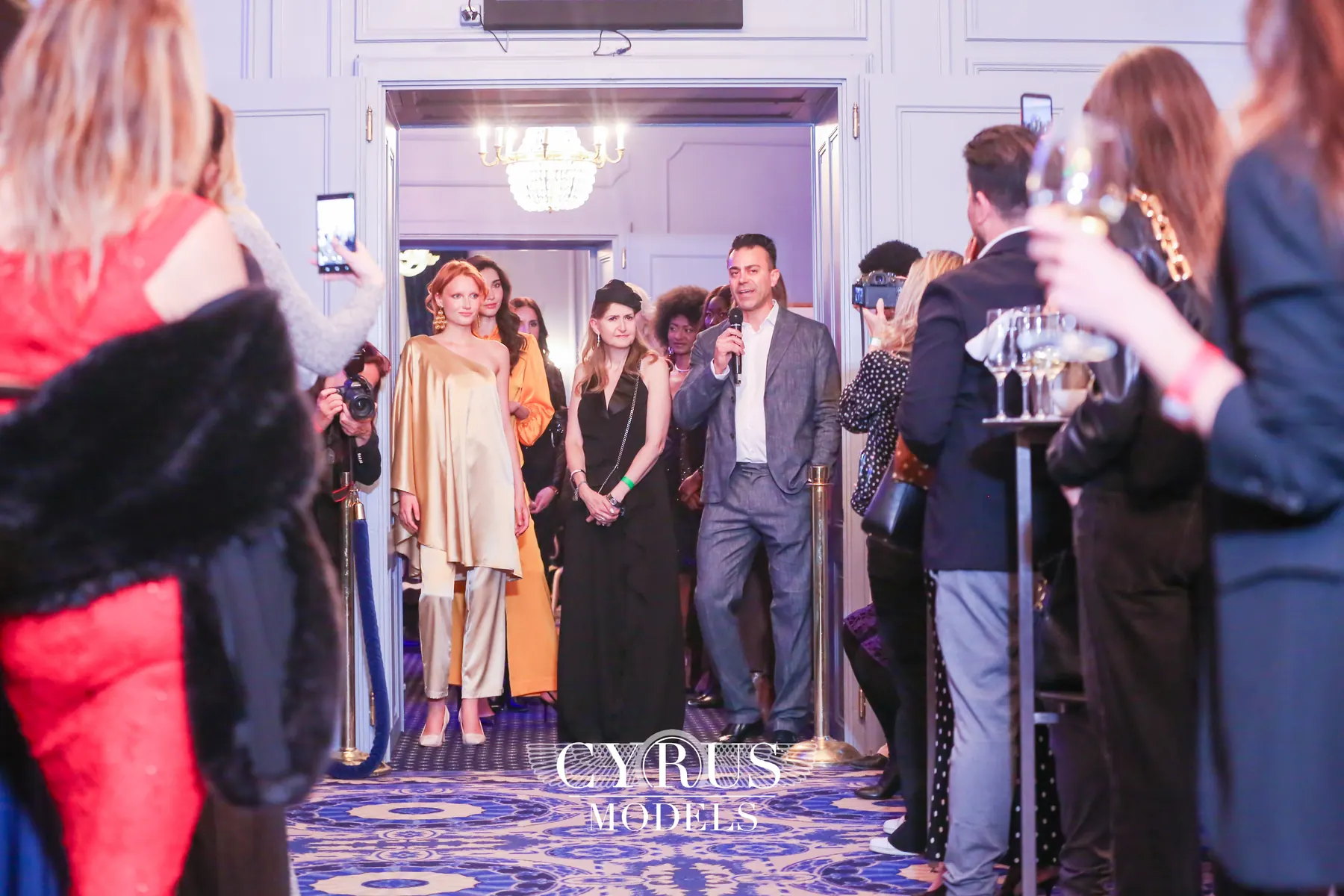 Models and guests interacting in front of a partner brand wall