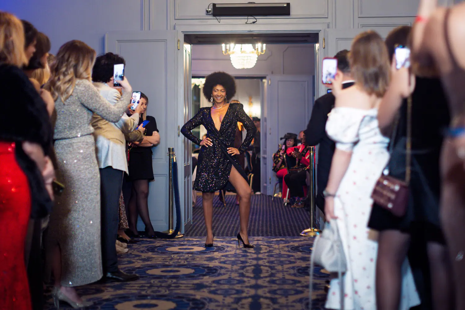 Model in a black sequined dress at the end of the runway