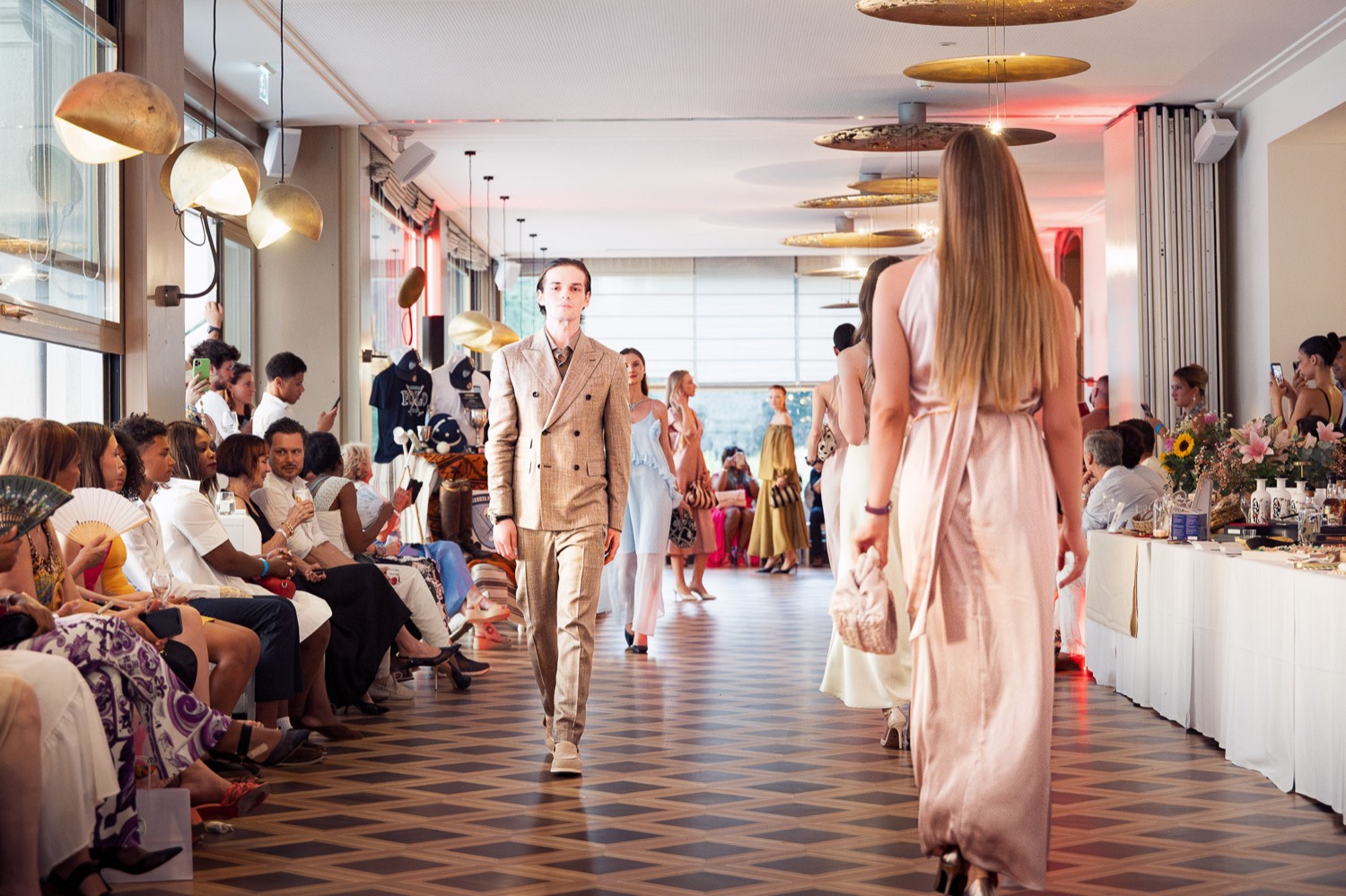 Models walking the runway between guests at a previous Fashion Night